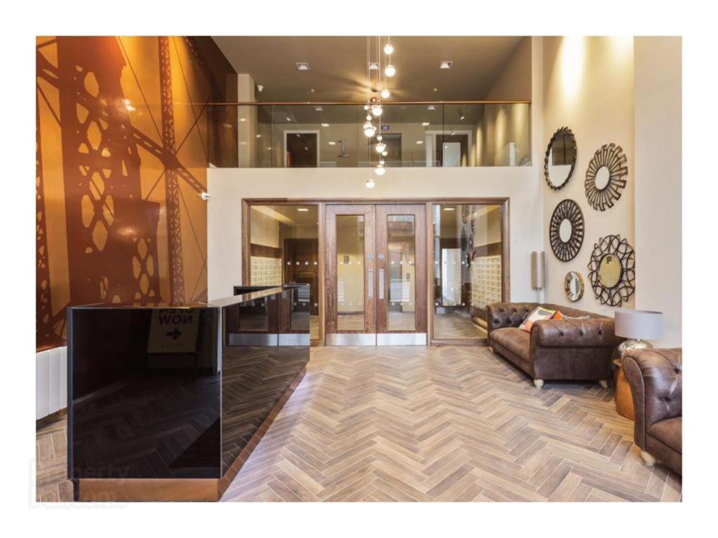ein Wohnzimmer mit Sofa und Tisch in der Unterkunft Aqua Dream Luxury Apartment-Coyles Place at Portland 88 in Belfast