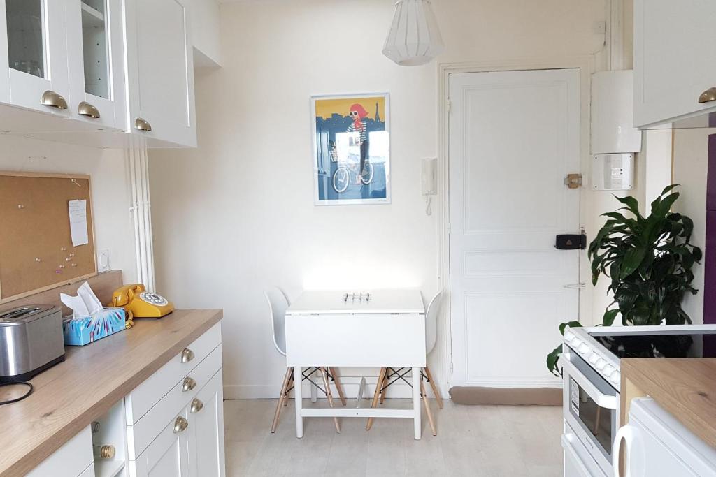 a kitchen with a white table and a white chair at Luxurious Apartment Near Parc André Citröen in Paris