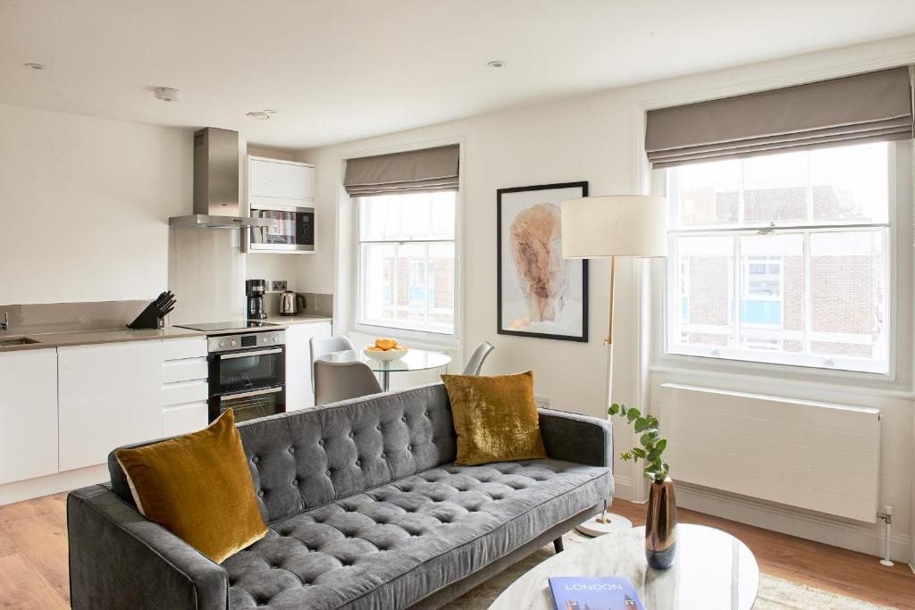 a living room with a couch and a kitchen at Sonder Inverness Mews in London