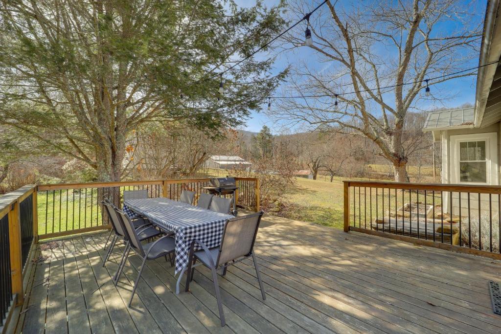 un tavolo e sedie su una terrazza in legno di Idyllic Blue Ridge Mountain Home on 26-Acre Farm a Roan Mountain