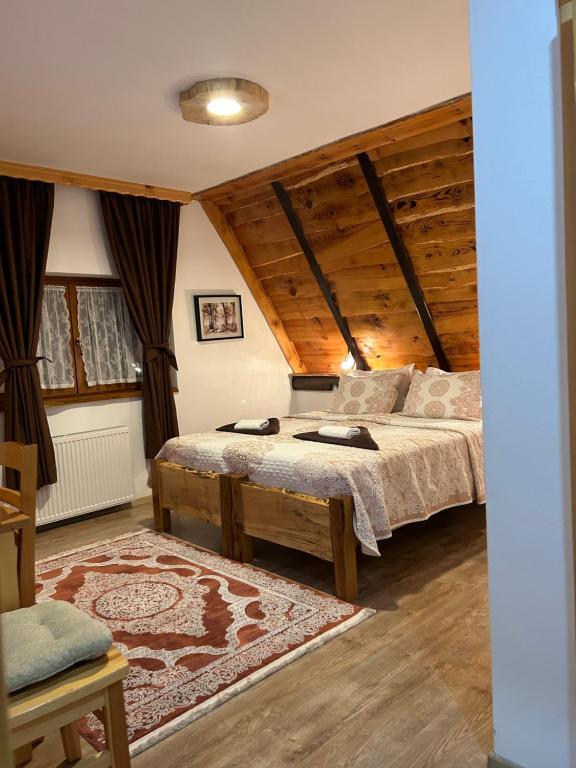 um quarto com uma cama num quarto com tectos em madeira em Rustic Lodge Plitvice em Plitvicka Jezera