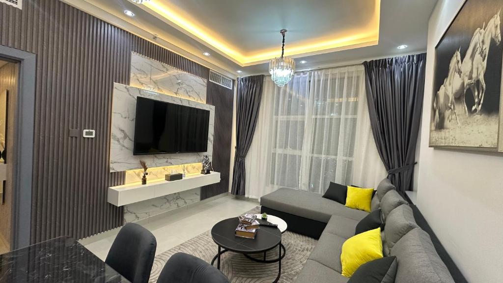a living room with a couch and a tv at Luxury 2 bedroom new brand in Ajman 