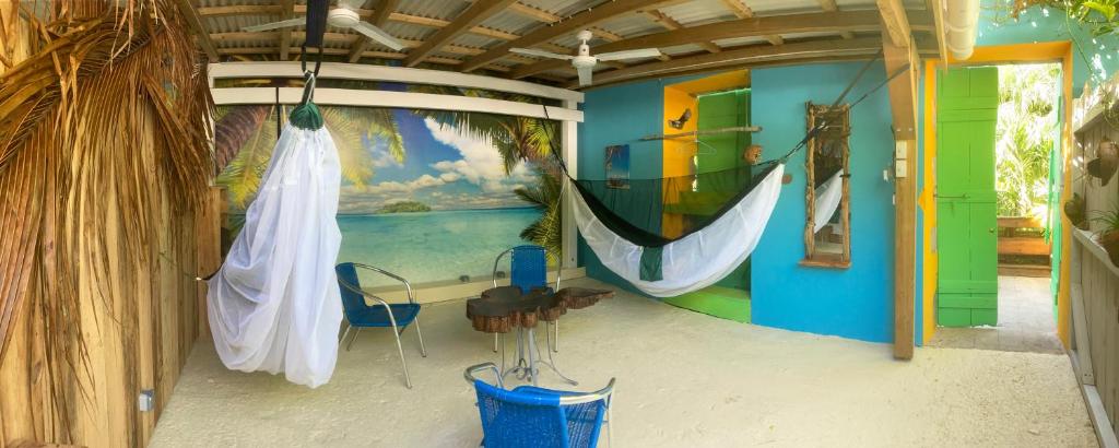 une chambre avec un hamac et un tableau sur le mur dans l'établissement LES HAMACS AUX SAINTES BIS, à Terre-de-Haut