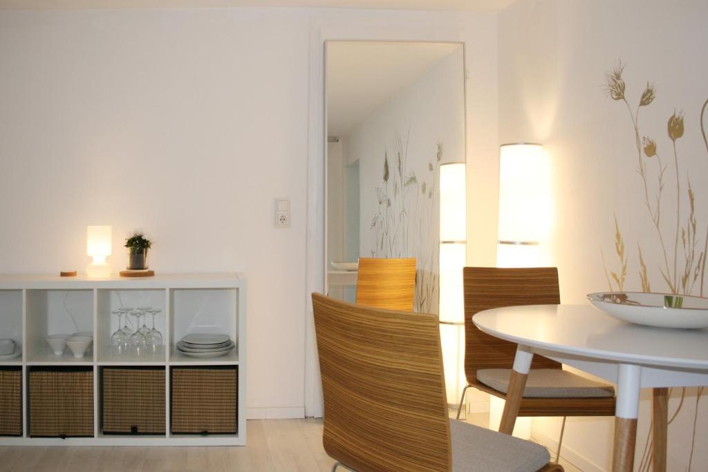 - une salle à manger avec une table, des chaises et un miroir dans l'établissement Landhaus Refugium, à Weissach