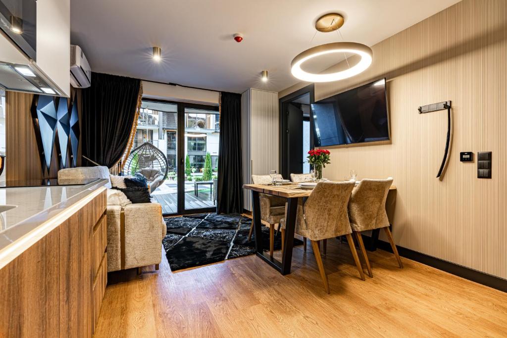 Open-plan living and dining area with wooden table, sofa and sliding glass doors to terrace.