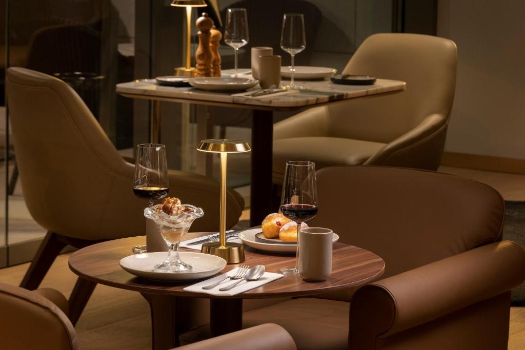 a table with glasses of wine and food on it at EVOLUTION Cascais-Estoril Hotel in Estoril