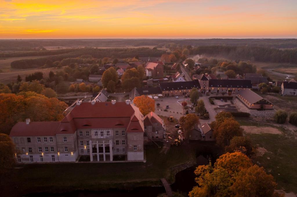 an aerial view of a building with a sunset in the background at Pałac Siemczyno in Siemczyno