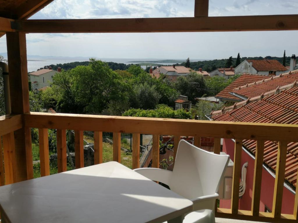 a balcony with a white chair and a view at Zefir Apartments in Premantura