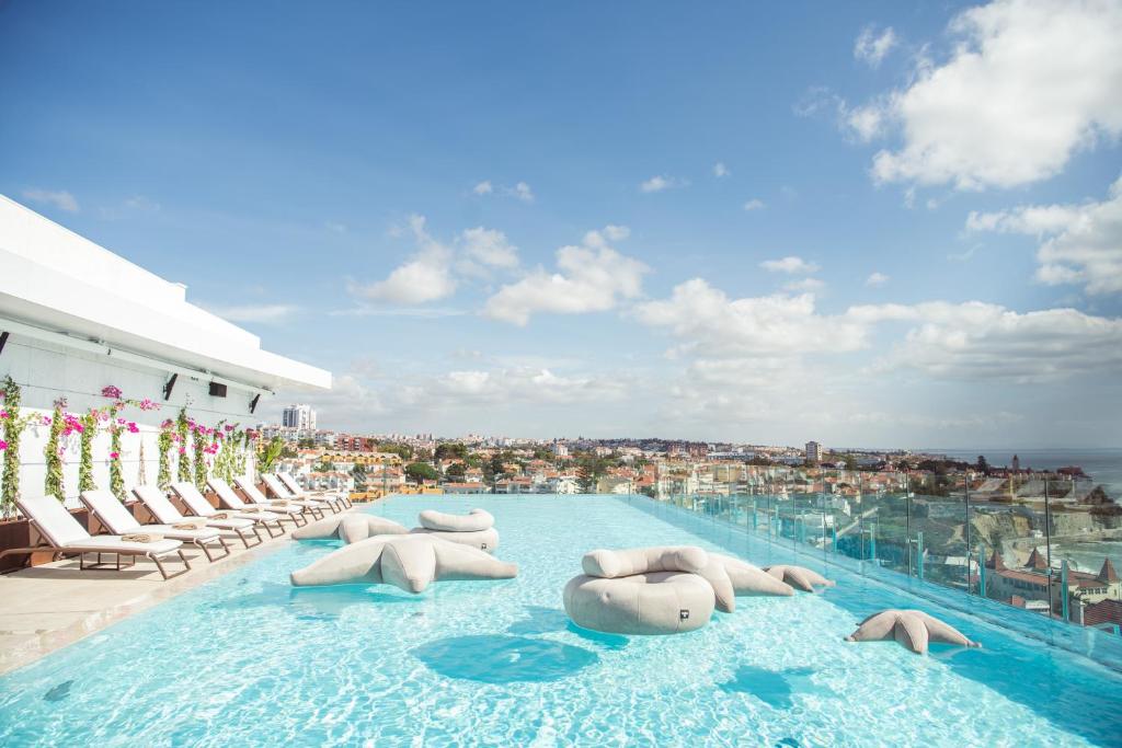 a swimming pool with lounge chairs on a building at EVOLUTION Cascais-Estoril Hotel in Estoril
