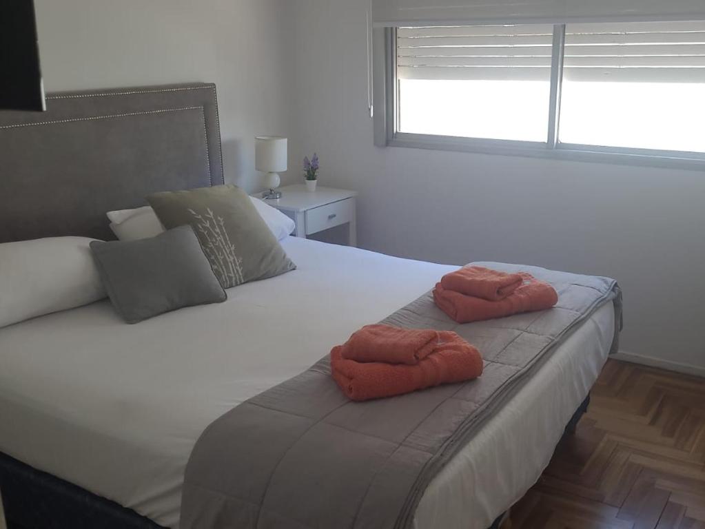 1 dormitorio con 1 cama con 2 toallas en Luminoso departamento en el corazón de la ciudad en Mar del Plata