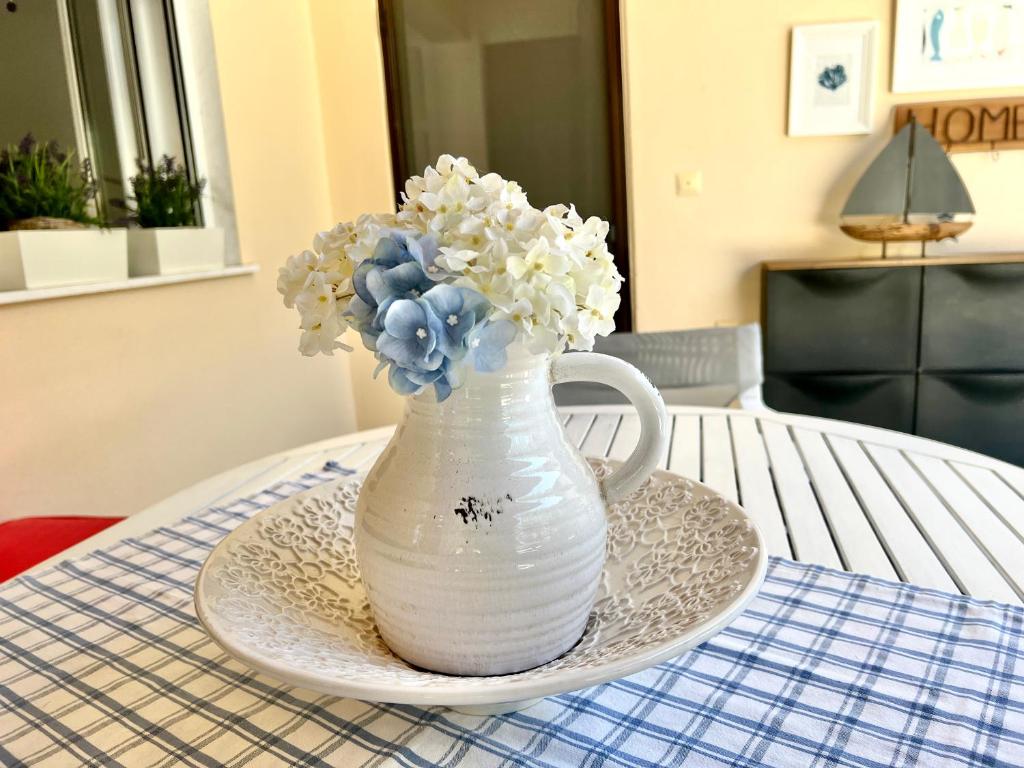 un vaso bianco con fiori blu e bianchi su un tavolo di Seaside villa Rebecca a Skála Nikíta
