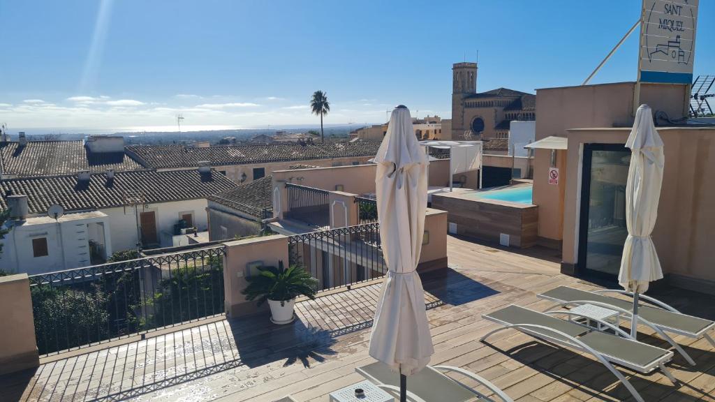 - un balcon avec deux parasols et une piscine dans l'établissement Boutique Hotel Petit Sant Miquel, à Calonge