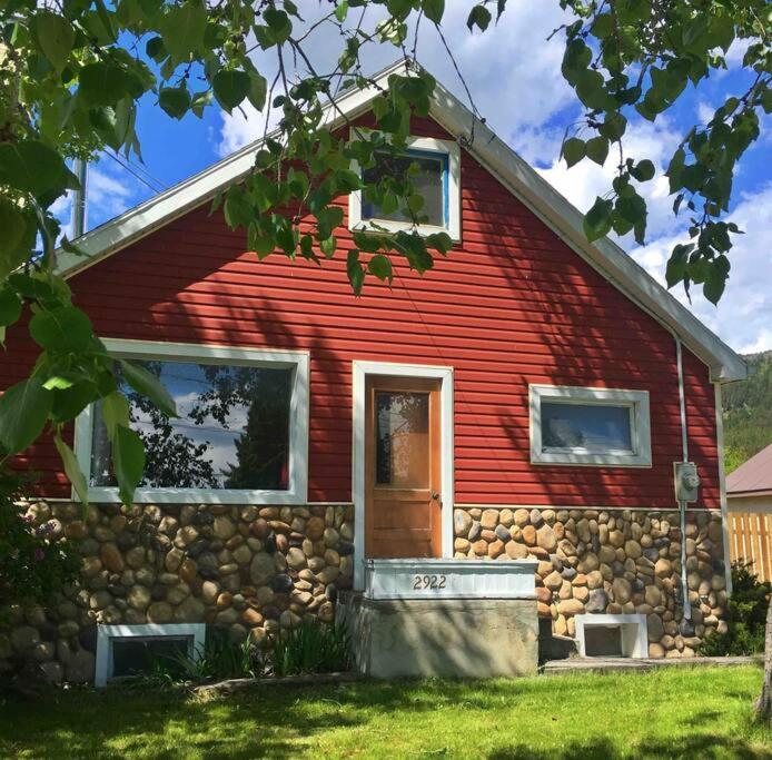 a red house with a stone wall at The Cozy Red Cabin in Bellevue