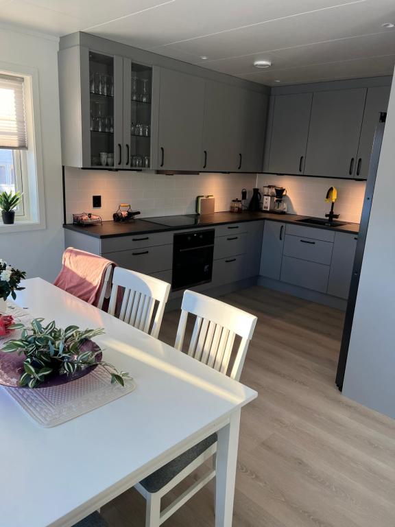 a kitchen with a white table and chairs in a room at Villaveien in Sortland