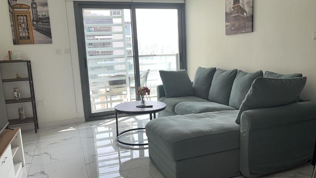 a living room with a couch and a table at Al Raha lofts 1 in Al Qurayyah