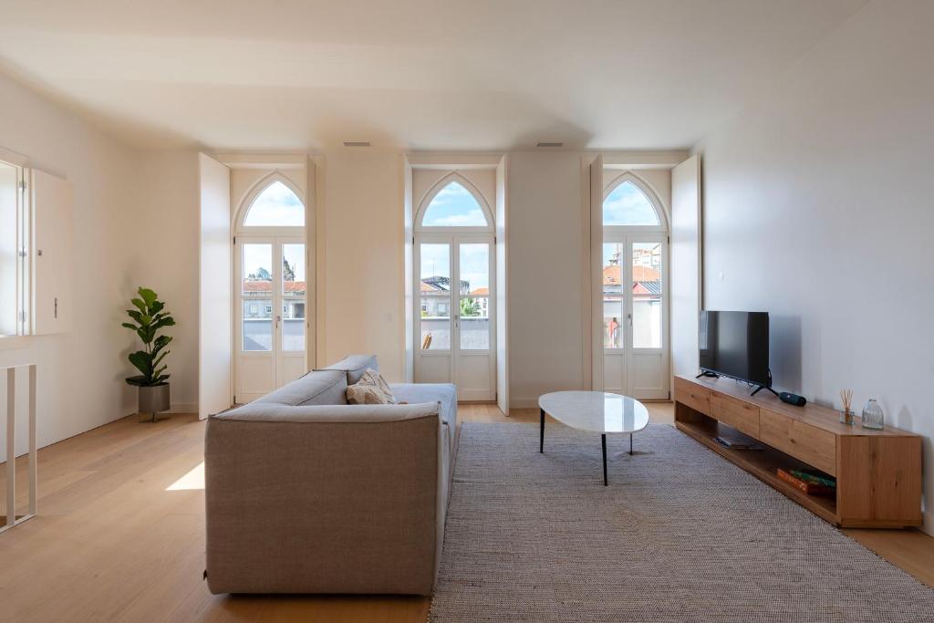 a living room with a couch and a tv at Mouzinho 32 in Porto