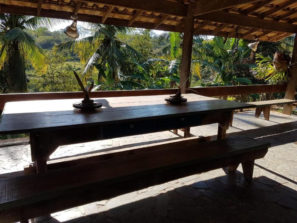 una mesa de madera con dos objetos encima en Pousada Vale Encantado Macaé en Macaé