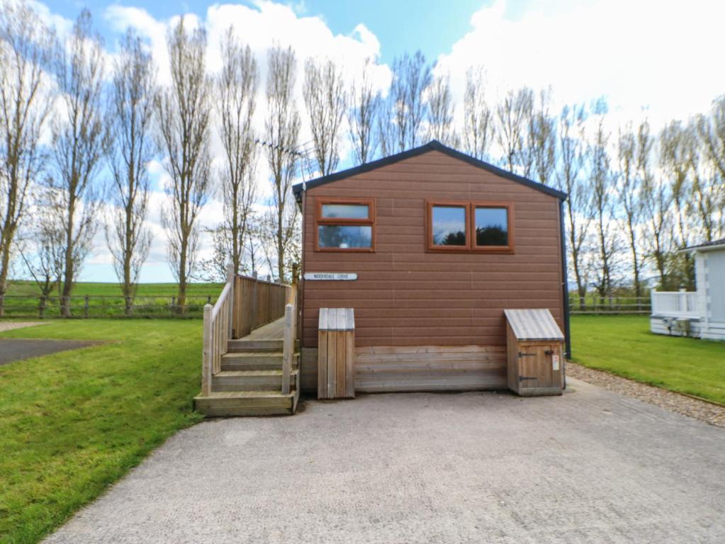 uma pequena casa com uma escada num campo em Nidderdale Pod em Yarm