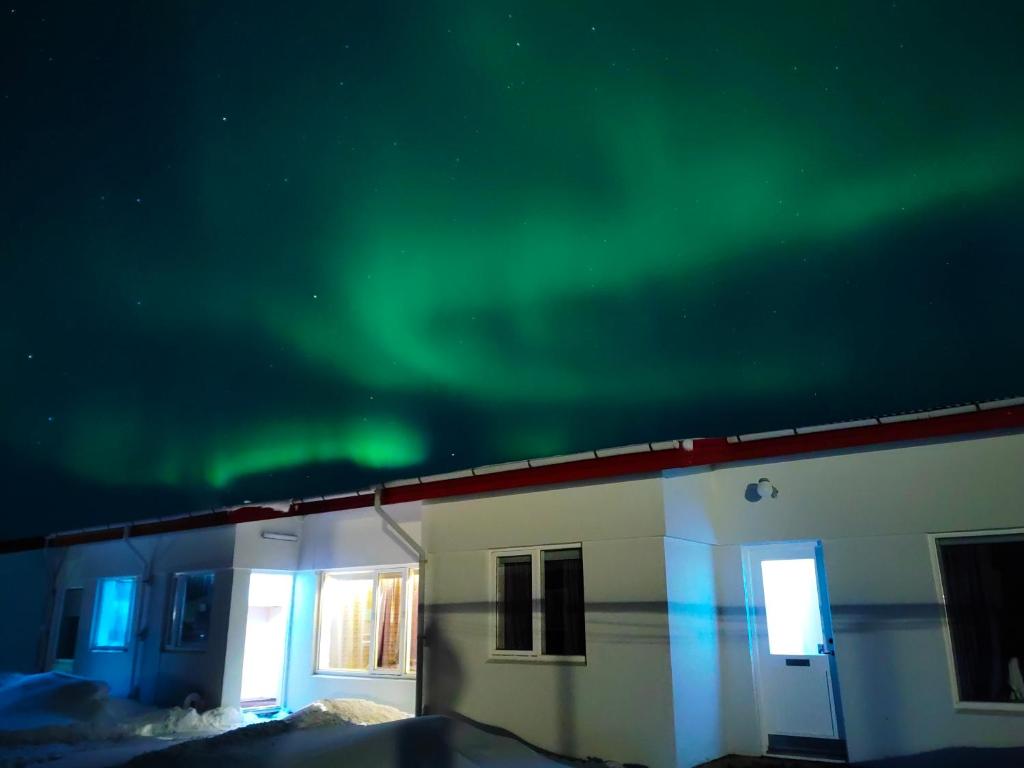 Ein Gebäude mit der Aurora im Himmel in der Unterkunft Eldá Guesthouse in Mývatn