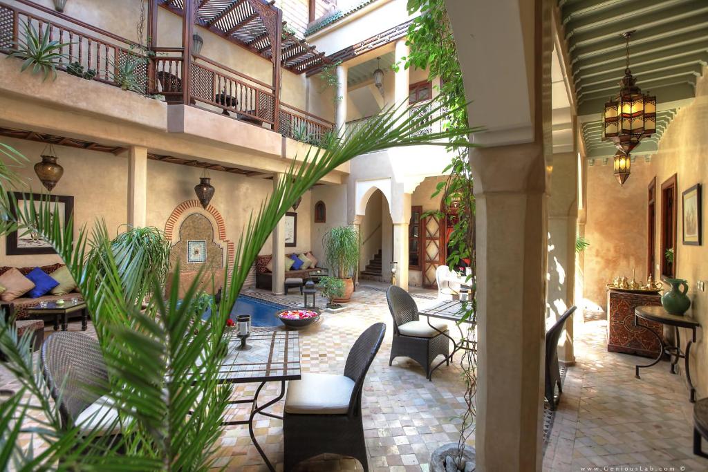 an indoor courtyard with tables and chairs and plants at Riad Zayane in Marrakesh