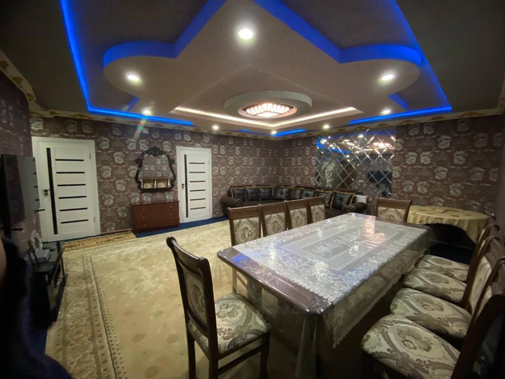 a dining room with a table and chairs with blue lights at Apartment Registan in Samarkand