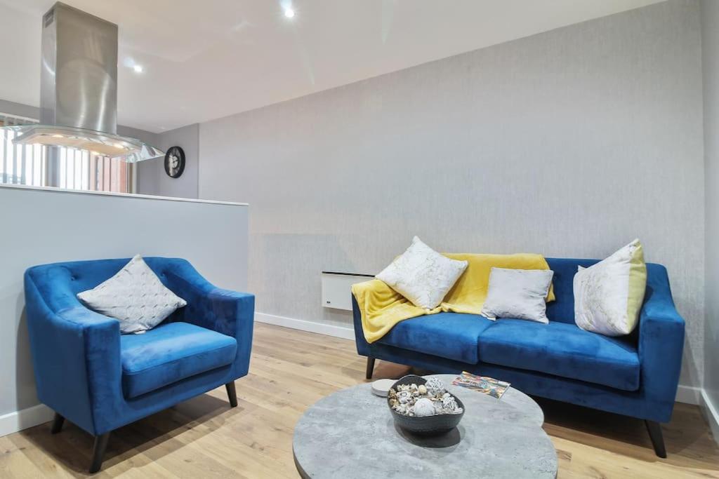 a living room with a blue couch and two chairs at Stylish modern home in Sheffield in Sheffield