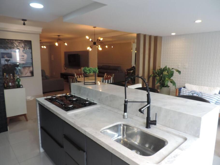 Apartamento Alto Padrão في غوارويا: مطبخ مع حوض وطاولة عمل