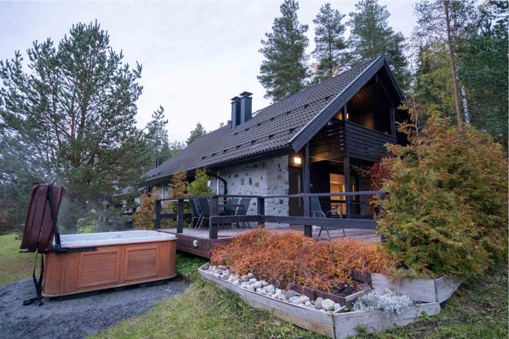 a log cabin with a hot tub in front of it at Villa Alppihimos - 6 henkilölle, Keski-Himos, 45m² + 33m² in Jämsä