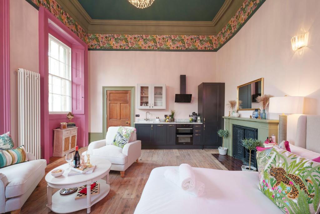 een woonkamer met roze muren en een open haard bij The Rose Nobel - 1 Bed Studio Apartment in Bristol by Mint Stays in Bristol