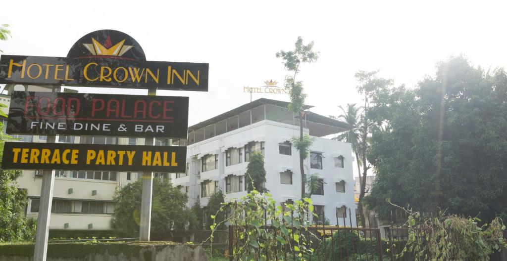 a hotel room inn sign in front of a building at Crown Inn in Panvel