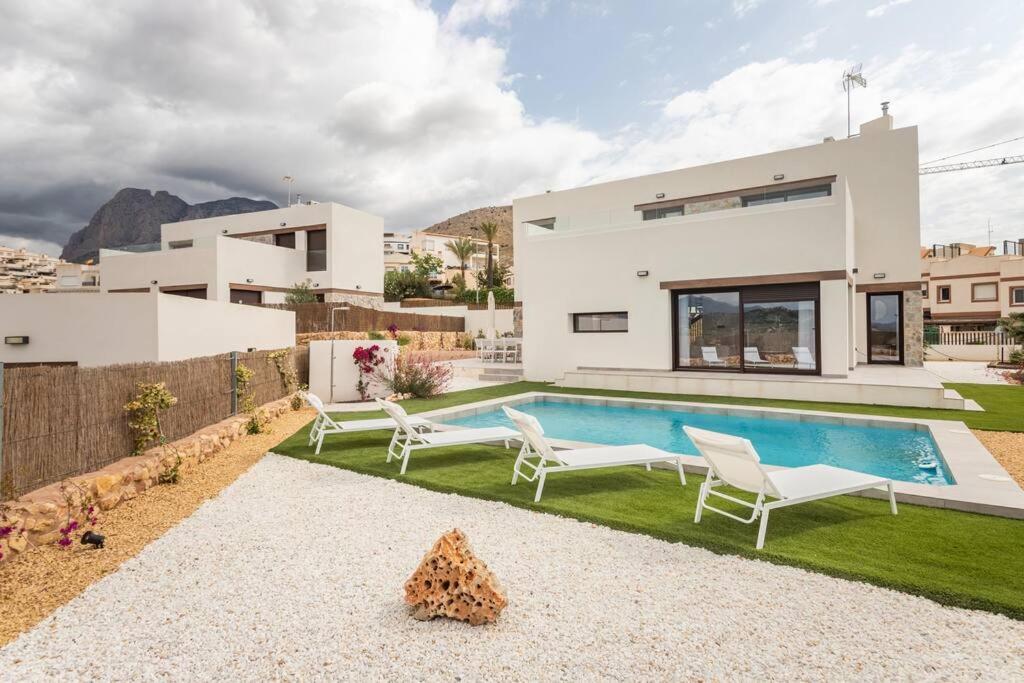 uma villa com uma piscina e uma casa em Superbe villa vue mer pour des vacances de rêve em Finestrat