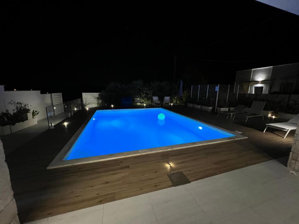 ein großer blauer Pool in der Nacht in der Unterkunft Il marchese in piscina in San Pietro in Bevagna