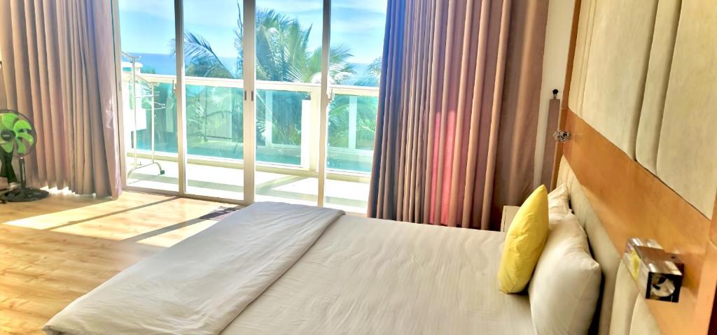 1 dormitorio con cama y ventana grande en Căn hộ OCEAN 2PN view nhìn ra biển A212, en Ấp Ngọc Hải