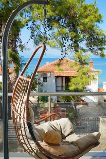 a swinging chair with a view of a house at Sunside House in Skala Kallirachis