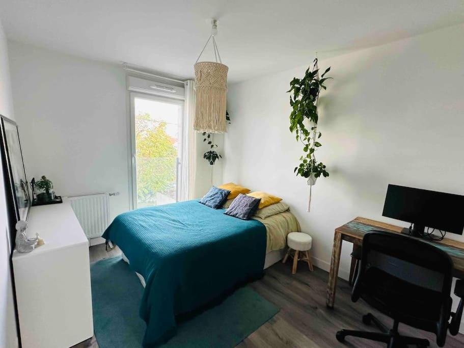 - une chambre avec un lit doté d'une couverture bleue et d'un bureau dans l'établissement Cozy appart near la defense & Paris, à Bezons