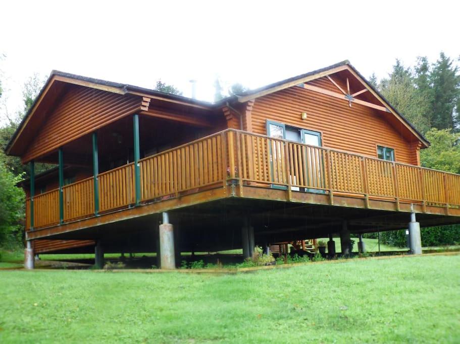 une grande maison en bois avec une grande terrasse dans l'établissement Escape to the Cabin, à Belturbet