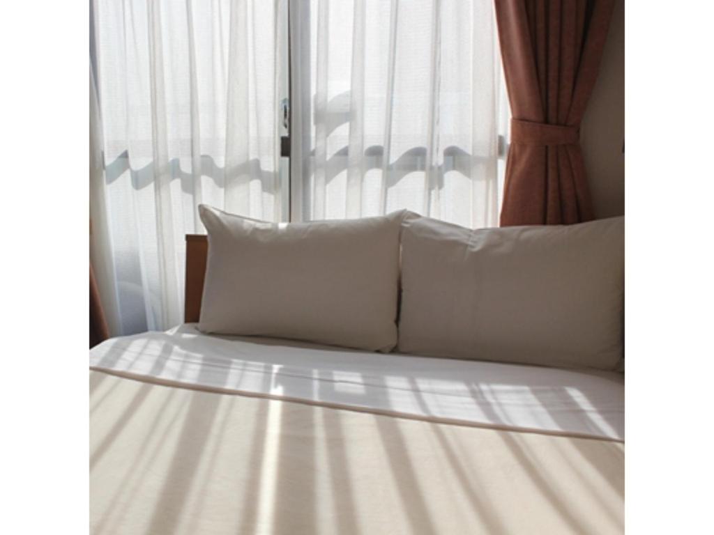 1 cama con almohadas blancas y ventana en Hotel Tetora Ikebukuro - Vacation STAY 36269v, en Tokio