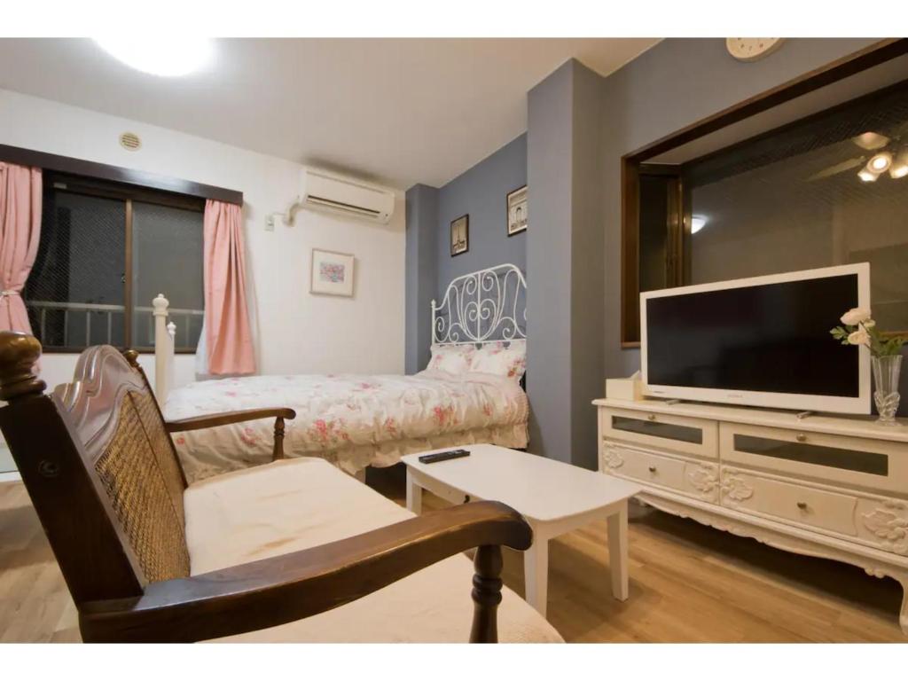 a living room with a couch and a television at Mini Hotel Shinjuku Front - Vacation STAY 89788v in Tokyo
