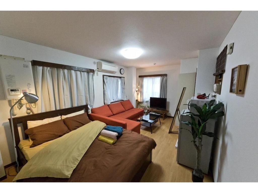 uma sala de estar com um sofá e uma sala de estar com em Mini Hotel Shinjuku Front - Vacation STAY 89774v em Tóquio