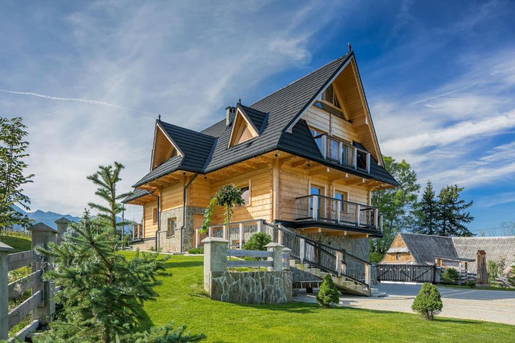 ein großes Holzhaus mit schwarzem Dach in der Unterkunft Rent like home - Willa Zoniówka in Zakopane