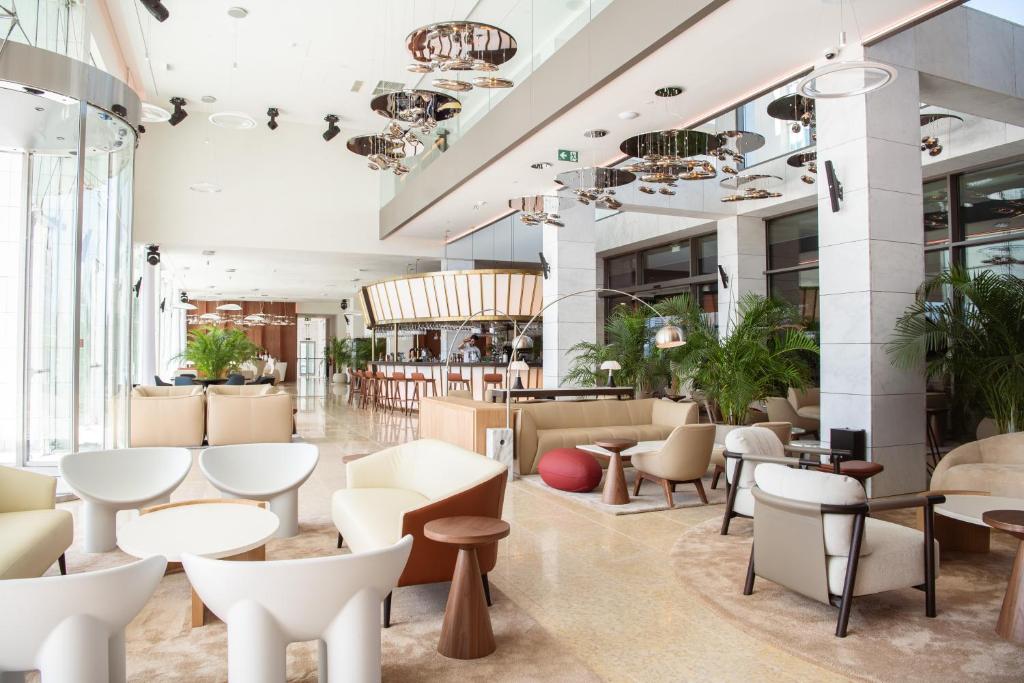 a lobby of a hotel with tables and chairs at EVOLUTION Cascais-Estoril Hotel in Estoril