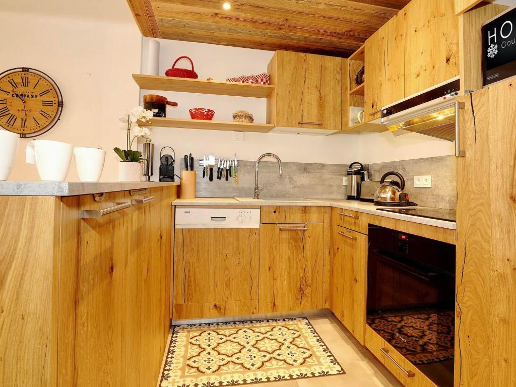 a kitchen with wooden cabinets and a sink at Appartement Courchevel 1850, 3 pièces, 4 personnes - FR-1-575-35 in Courchevel