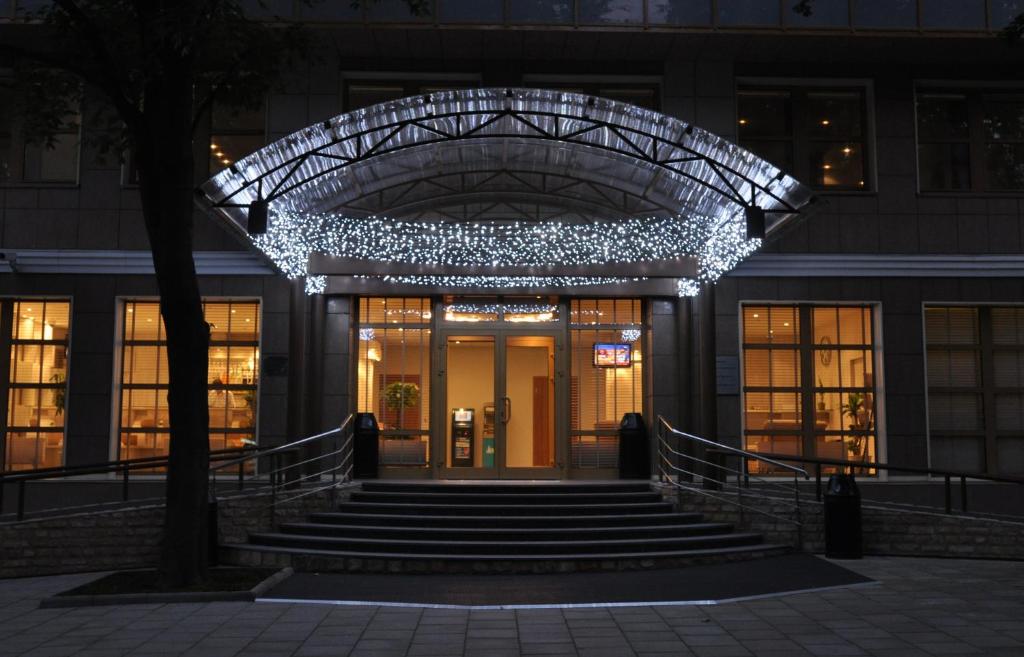 un edificio con una escalera que conduce a un edificio con luces en D` Hotel VDNKH, en Moscú