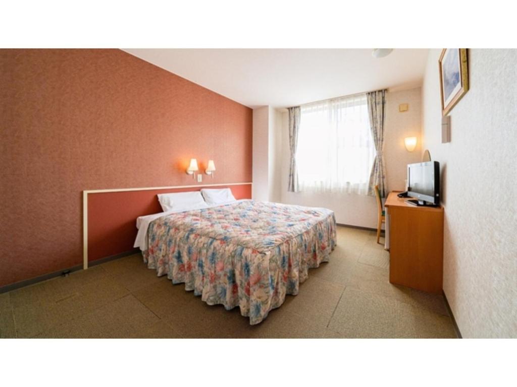 TobeにあるKutsurogi no Yado Juraku - Vacation STAY 03506vのベッドとテレビが備わるホテルルームです。