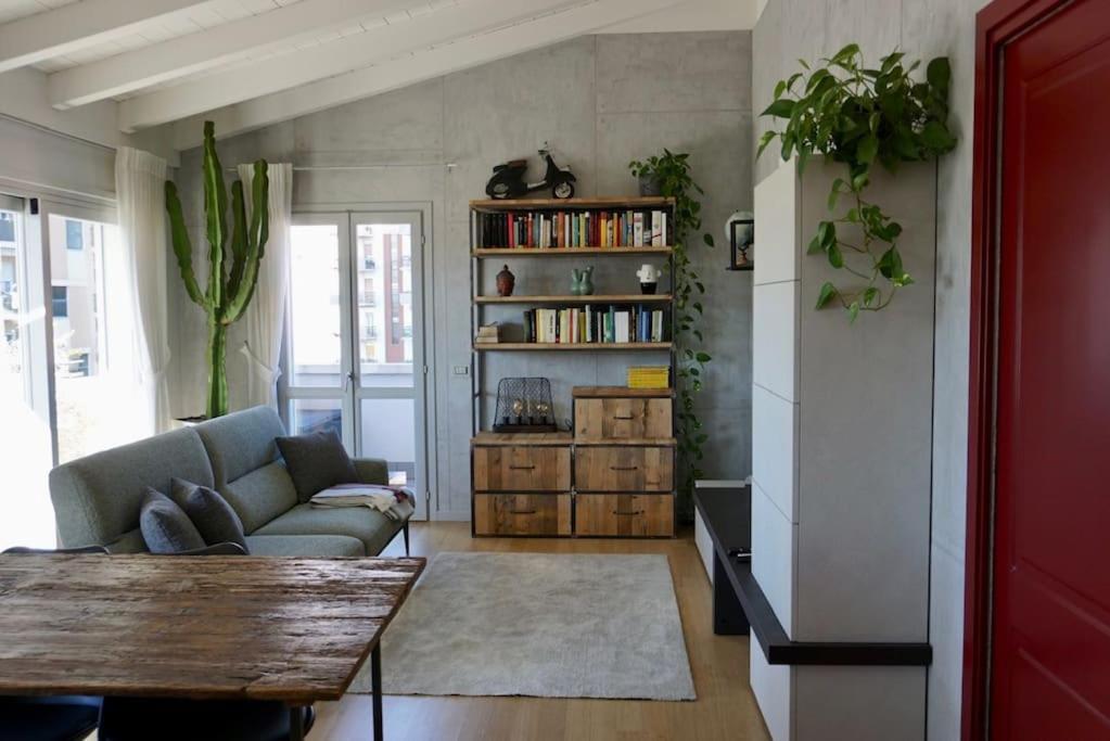 a living room with a couch and a book shelf at Le Terrazze 18 in Brescia