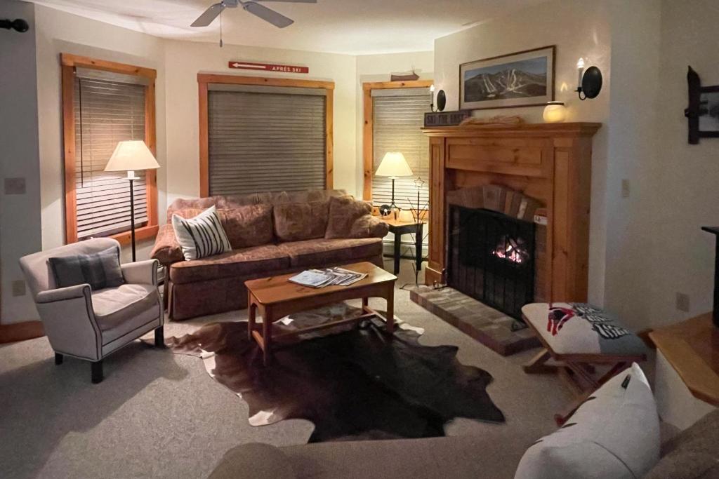 a living room with a couch and a fireplace at Jay Peak Village Home 375 in Jay