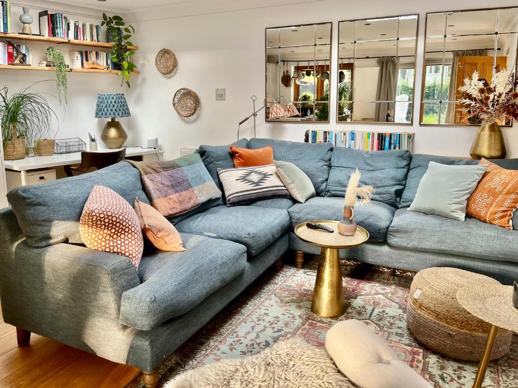 a living room with a blue couch with pillows at Crescent Lodge, Crouch End, London in London