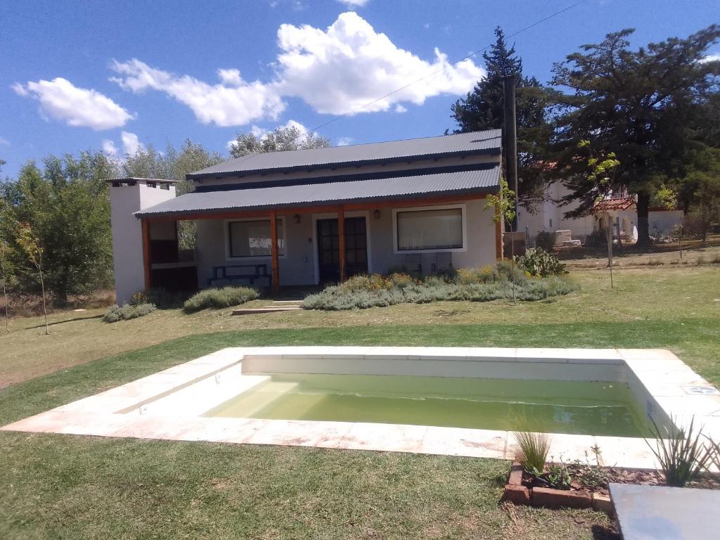 una casa con una piscina de agua en el patio en La Pasiva en Villa Giardino
