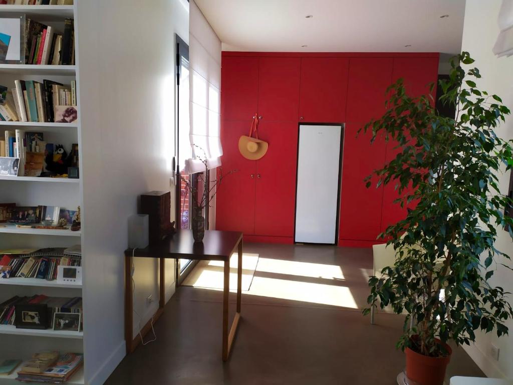 a room with a red wall and a table and a door at Appartement de 2 chambres avec vue sur la ville terrasse amenagee et wifi a Saint Ouen in Saint-Ouen