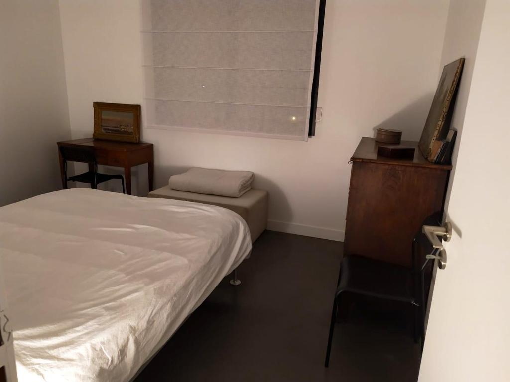 a small bedroom with a bed and a dresser and a window at Appartement de 2 chambres avec vue sur la ville terrasse amenagee et wifi a Saint Ouen in Saint-Ouen